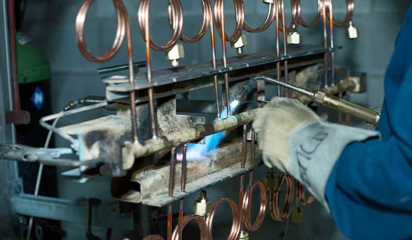 Un home qui est entrain de souder une pièce.