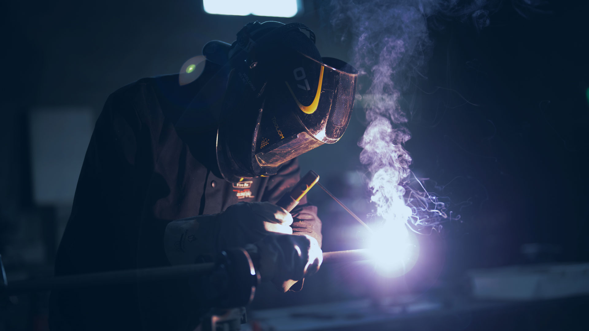 Un homme qui est entrain de souder une pièce.