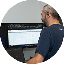 Un homme devant un ordinateur entrain de travailler.