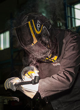 Homme qui est entrain de souder un morceau.